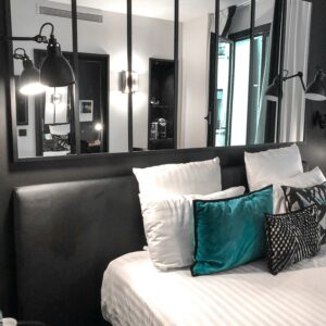 Stylish bedroom featuring modern decor, plush pillows, and large mirrors enhancing the space.